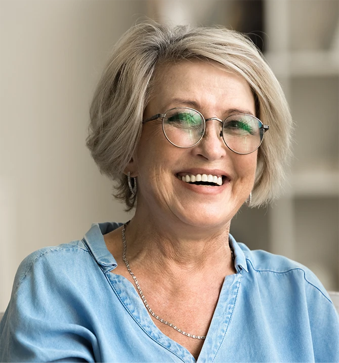 Bild zeigt eine ältere Frau mit Brille, die am Lachen ist
